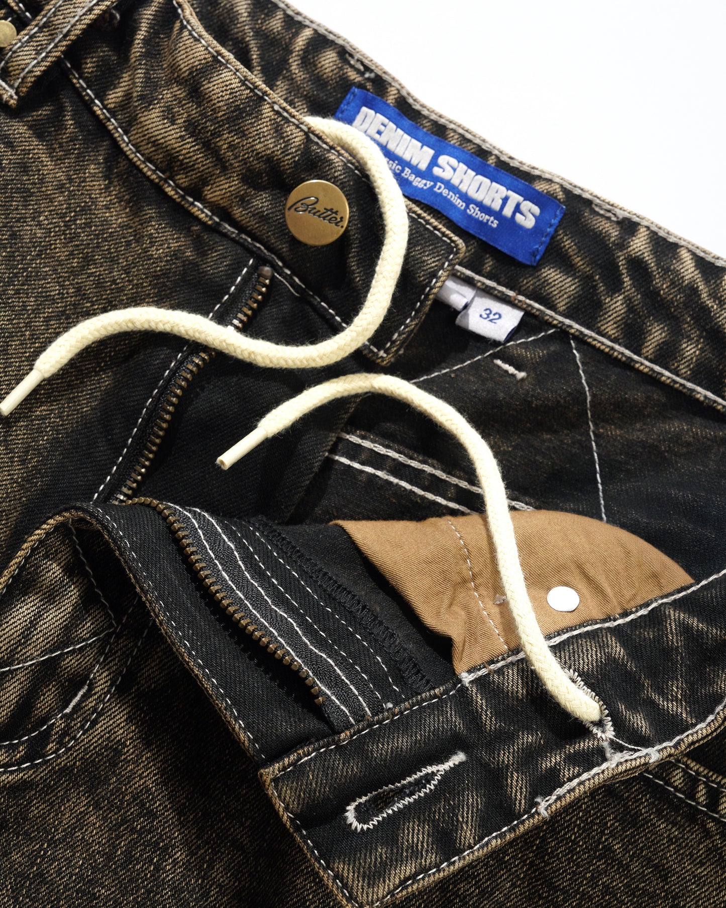 Close-up of a denim short with a brand label on a white background