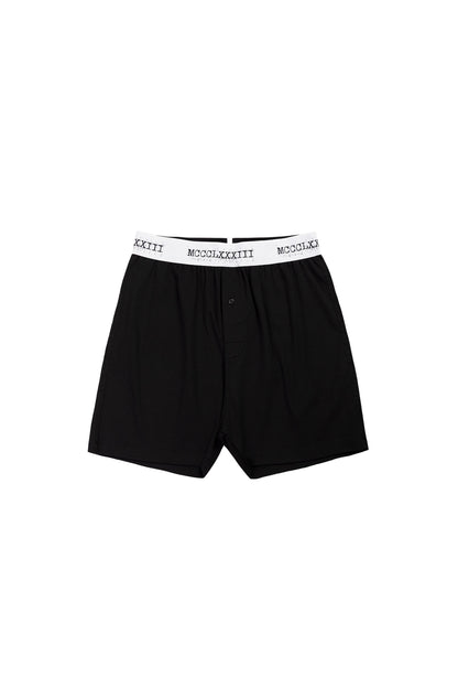Black boxer briefs with white waistband on a white background