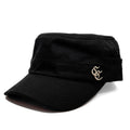 A black military-style cap with a curved brim and a small gold embroidered monogram logo on the side, shown against a plain white background.