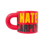 Red mug with yellow and black text 'I HATE CARPET' on a white background
