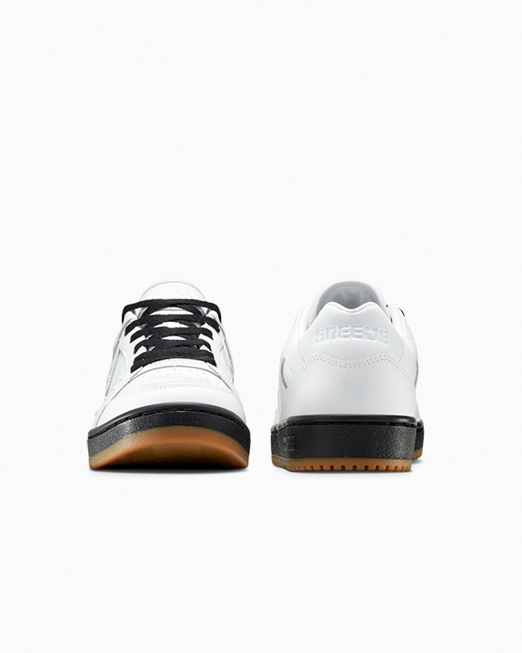 White sneakers with black soles on a white background