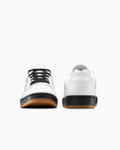 White sneakers with black soles on a white background