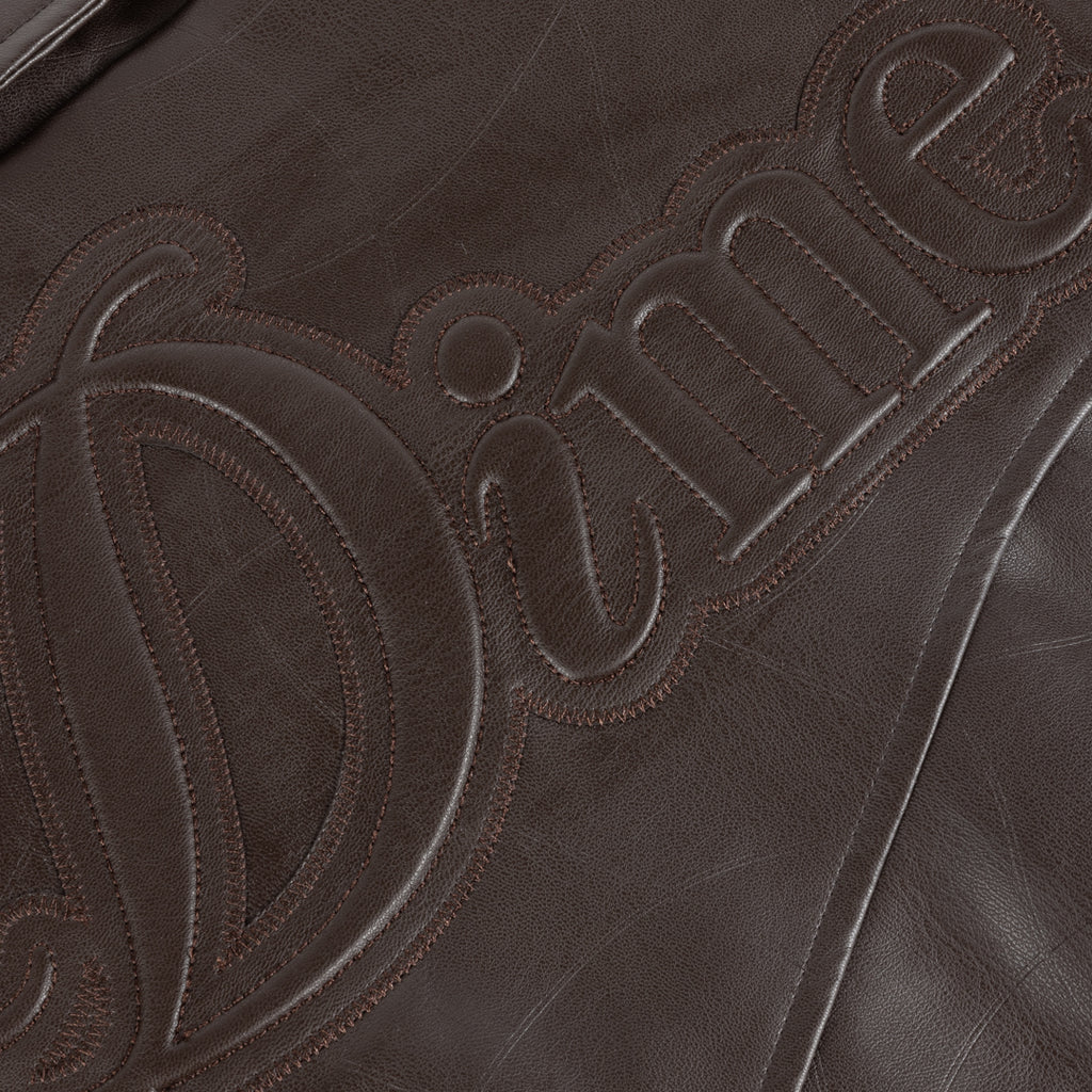 Close-up of a brown leather surface with 'Dime' branding.