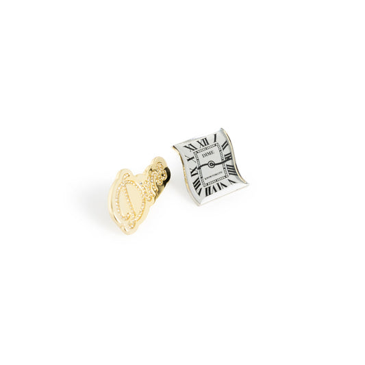 Gold and silver clock-shaped earrings on a white background