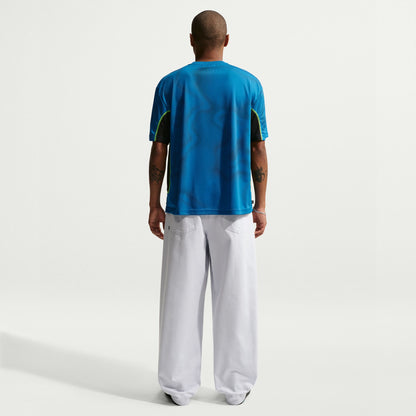 Person wearing a blue sports jersey and white pants on a white background