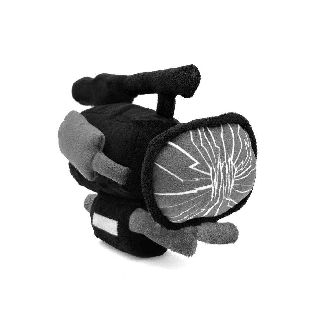 A plush toy shaped like a vintage television camera, featuring black and gray fabric with a cracked screen design and a small white rectangular detail on the lower front, set against a plain white background.
