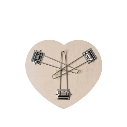 Heart-shaped wooden clip with metal clips on a white background